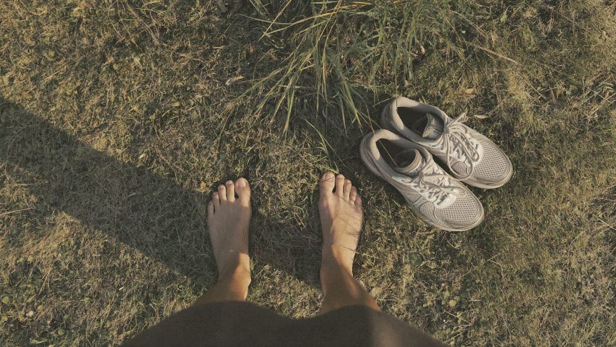 Bare feet on dewy grass, shoes set aside