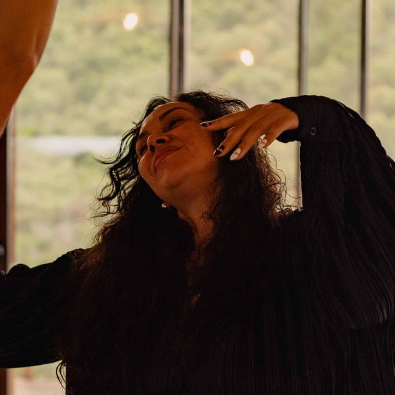 Camila Mello mid-movement in the retreat room, head tilted back, eyes closed